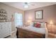 Inviting bedroom with a dark wood bed frame, soft lighting, and quaint decor, complete with ceiling fan at 16331 Burniston Dr, Tampa, FL 33647