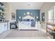 Bright main bedroom with blue accent wall, white furnishings, and a functional breakfast bar area at 16331 Burniston Dr, Tampa, FL 33647