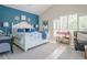 This main bedroom features a decorative wall, a white bed frame and a large window for ample natural light at 16331 Burniston Dr, Tampa, FL 33647