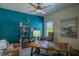 Well-lit office with a dark teal accent wall, wood desk, and shelving unit adding character to the space at 16331 Burniston Dr, Tampa, FL 33647