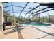 Screened-in pool area with lounge chairs and lush landscaping, perfect for outdoor relaxation and enjoyment at 16331 Burniston Dr, Tampa, FL 33647