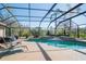 Screened-in pool with beautiful backyard view and chairs for lounging on the deck. Hot tub to the left at 16331 Burniston Dr, Tampa, FL 33647
