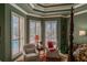 Comfortable sitting area in the main bedroom features bright light from large windows and elegant furnishings at 16331 Burniston Dr, Tampa, FL 33647
