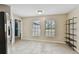 Dining area with tile flooring, natural light from windows, and stainless steel refrigerator at 16508 Round Oak Dr, Tampa, FL 33618