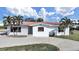 Charming waterfront home featuring a red tile roof, lush palm trees and a circular driveway at 17401 1St E St, Redington Shores, FL 33708