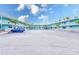 Exterior shot of the resort condos featuring balconies, and an abundance of palm trees for a tropical feel at 19417 Gulf Blvd # D-206, Indian Shores, FL 33785