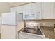 Well-equipped kitchen featuring modern white appliances, and granite countertops at 19417 Gulf Blvd # D-206, Indian Shores, FL 33785