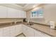 Compact kitchen features white cabinets, modern appliances, and granite countertops at 19417 Gulf Blvd # D-206, Indian Shores, FL 33785