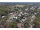 Aerial view shows a neighborhood with homes and mature trees, and an open landscape with ball fields at 245 Faithway Dr, Seffner, FL 33584