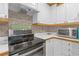 Galley kitchen features white cabinetry, modern appliances, and an eye-catching decorative backsplash at 245 Faithway Dr, Seffner, FL 33584
