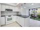 Kitchen featuring a mosaic backsplash, granite countertops and stainless steel appliances with outdoor access at 2473 Bentley Dr, Palm Harbor, FL 34684