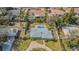 An aerial view of a home with a pool, surrounded by a white fence, a manicured lawn, and mature trees at 306 Indian Rocks S Rd, Largo, FL 33770