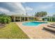 Inviting backyard featuring a sparkling pool, lounge seating, and an outdoor living area at 306 Indian Rocks S Rd, Largo, FL 33770