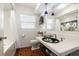 A well-lit bathroom with unique sink and vanity, tub, shower, and a tiled floor pattern at 306 Indian Rocks S Rd, Largo, FL 33770