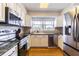 Well-lit kitchen featuring stainless steel appliances, white cabinets, and a view from above the sink at 306 Indian Rocks S Rd, Largo, FL 33770