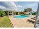 A refreshing pool with lounge chairs, patio, and a view of the home's back exterior at 306 Indian Rocks S Rd, Largo, FL 33770
