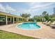 Well-manicured backyard with a beautiful pool, sun loungers, and covered patio at 306 Indian Rocks S Rd, Largo, FL 33770