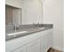 Bright bathroom featuring a double sink vanity with gray countertops and white cabinets at 31818 Treasure Dock Isle, Wesley Chapel, FL 33545