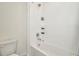 Clean white tiled bathroom with a tub and shower combination, complete with sleek fixtures at 31818 Treasure Dock Isle, Wesley Chapel, FL 33545