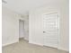 Bright bedroom with carpet, paneled doors, and a glimpse into a closet/storage area at 31818 Treasure Dock Isle, Wesley Chapel, FL 33545