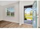 Bright foyer with hardwood floors, a window view of the neighborhood, and a stylish blue front door at 31818 Treasure Dock Isle, Wesley Chapel, FL 33545