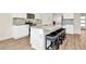 Modern kitchen features white cabinets, stainless steel appliances, and an island with bar stool seating at 31818 Treasure Dock Isle, Wesley Chapel, FL 33545