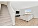 Bright living room with stairs, wood floors, large sectional, and natural light at 31818 Treasure Dock Isle, Wesley Chapel, FL 33545
