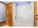 Bathroom showcasing a shower and bathtub combination with white tiling, and wooden door at 3917 Appletree Dr, Valrico, FL 33594