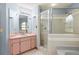 Bright bathroom with a tiled walk-in shower, soaking tub, and a light pink vanity at 3917 Appletree Dr, Valrico, FL 33594