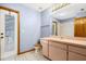 Bathroom featuring a large vanity, toilet, mirror, and a door to the outside pool area at 3917 Appletree Dr, Valrico, FL 33594