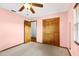 Bedroom showcasing a ceiling fan, wood closet doors, neutral carpet, and a window for natural light at 3917 Appletree Dr, Valrico, FL 33594