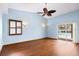 Vaulted ceiling bedroom with dark wood floors, light blue walls, a ceiling fan and access to the pool at 3917 Appletree Dr, Valrico, FL 33594