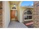 Inviting front entrance featuring a wooden door and brick-framed arched window at 3917 Appletree Dr, Valrico, FL 33594