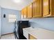 Laundry room featuring overhead wooden cabinets, washer and dryer and white sink at 3917 Appletree Dr, Valrico, FL 33594