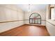 Open-concept living room with hardwood floors and arched windows with modern shutters at 3917 Appletree Dr, Valrico, FL 33594