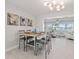 A formal dining room open to the living room with waterfront views, a modern chandelier and decor at 3961 12Th Ne St, St Petersburg, FL 33703