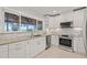 Beautiful kitchen with stainless appliances, white cabinets, and large window overlooking the water at 3961 12Th Ne St, St Petersburg, FL 33703