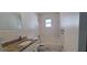Bathroom with tile, toilet, vanity, shower/tub, neutral paint, and a window at 4017 W Nassau St, Tampa, FL 33607