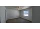 Bright carpeted bedroom with a ceiling fan, a window, and neutral paint throughout the room at 4017 W Nassau St, Tampa, FL 33607