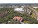 Breathtaking aerial view of a red-roofed condominium complex with commercial development, nestled amid trees at 4106 Central Sarasota Pkwy # 1023, Sarasota, FL 34238