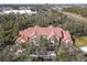 Aerial view of a building with red roofs surrounded by lush green trees at 4106 Central Sarasota Pkwy # 1023, Sarasota, FL 34238