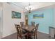 Bright dining area featuring a dark wood table, blue accent wall, and stylish light fixture at 4106 Central Sarasota Pkwy # 1023, Sarasota, FL 34238