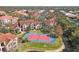 Aerial view of a blue and red tennis court in a residential community with lush landscaping and beautiful Mediterranean-style buildings at 4106 Central Sarasota Pkwy # 1023, Sarasota, FL 34238