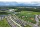Scenic aerial view of a community, school, sports fields, and surrounding landscape at 4132 Woods Rider Loop, Odessa, FL 33556