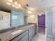 Bright bathroom featuring double sinks, granite counters, tile floors, and ample cabinet storage at 4132 Woods Rider Loop, Odessa, FL 33556