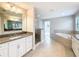 Bright bathroom with double vanity, granite countertop, walk-in shower, and a large soaking tub at 4132 Woods Rider Loop, Odessa, FL 33556