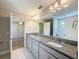 Bright bathroom featuring double sinks, granite counters, tile floors, and ample cabinet storage at 4132 Woods Rider Loop, Odessa, FL 33556