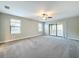 Large bedroom featuring carpeted floors, ceiling fan, and a sliding glass door to the outdoor patio at 4132 Woods Rider Loop, Odessa, FL 33556