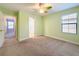 Sunny green bedroom with carpet, a ceiling fan, and natural light from the window at 4132 Woods Rider Loop, Odessa, FL 33556