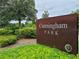 Community sign for Cunningham Park with lush landscaping and trees against a cloudy sky at 4132 Woods Rider Loop, Odessa, FL 33556